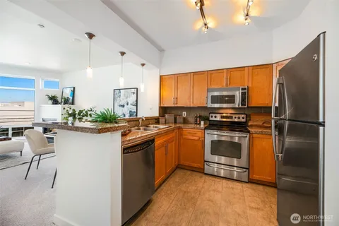a kitchen with stainless steel appliances granite countertop a refrigerator a stove a sink dishwasher and a refrigerator
