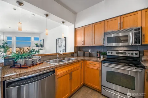 a kitchen with stainless steel appliances a stove a sink and a microwave