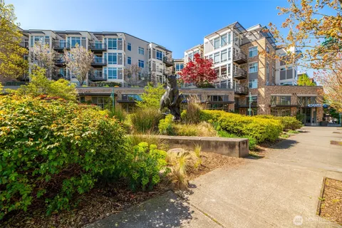 a front view of a multi story residential apartment building with yard
