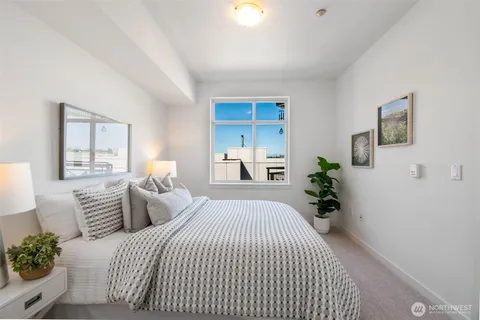 a bedroom with a bed and a potted plant