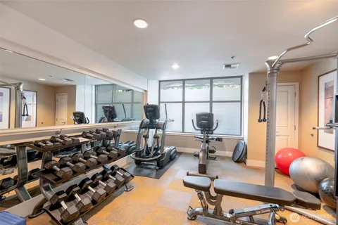 a living room with furniture a window and gym equipment