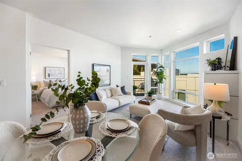 a living room with furniture potted plant and open kitchen view