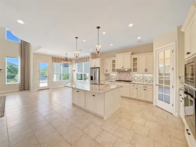 a large white kitchen with cabinets