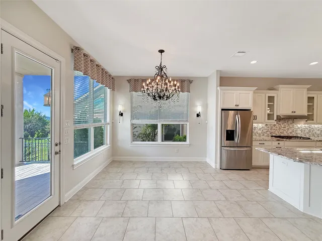 a large kitchen with a stove a refrigerator a sink dishwasher with a dining table and chairs