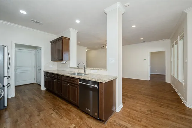 a kitchen with stainless steel appliances granite countertop a sink stove and refrigerator
