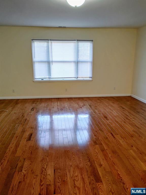 70 Willow Street, Unit 2 Bloomfield, NJ 07003 - Photo 2 of 8 an empty room with wooden floor and windows