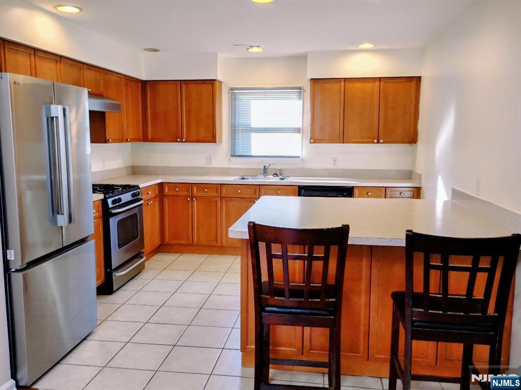 70 Willow Street, Unit 2 Bloomfield, NJ 07003 - Photo 4 of 8 a kitchen with stainless steel appliances granite countertop a stove a sink and a refrigerator