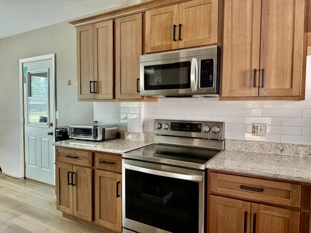 a kitchen with cabinets stainless steel appliances and wooden cabinets
