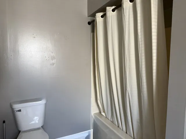 a bathroom with a toilet and a window