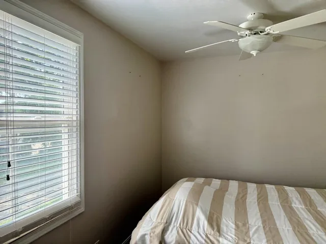 a view of a bedroom with a bed and a window