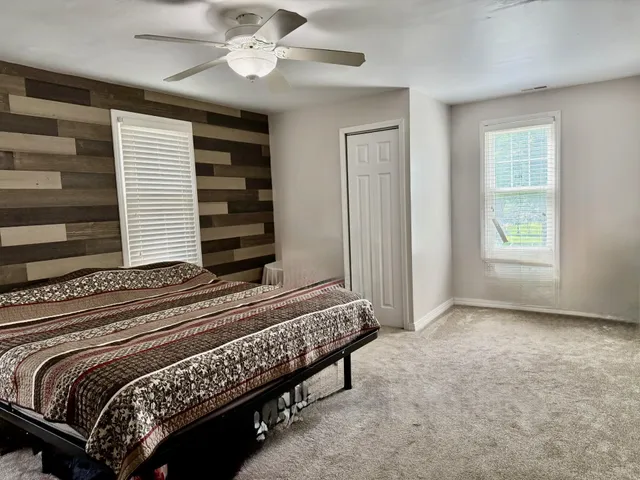 wooden floor with a bed and a window