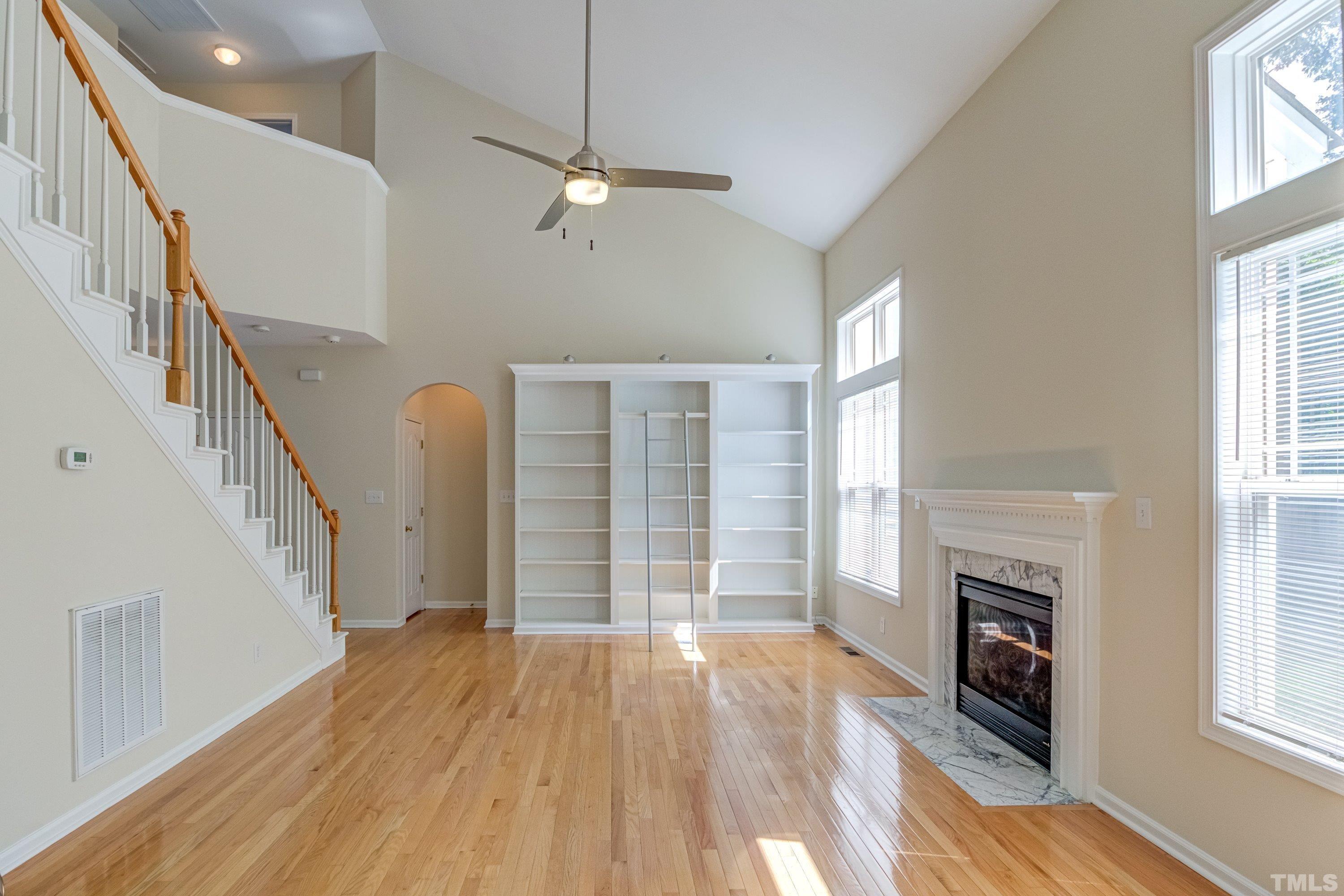 8613 Benzinger Drive Raleigh, NC 27613 - Photo 11 of 48 wooden floor fireplace and windows in an empty room