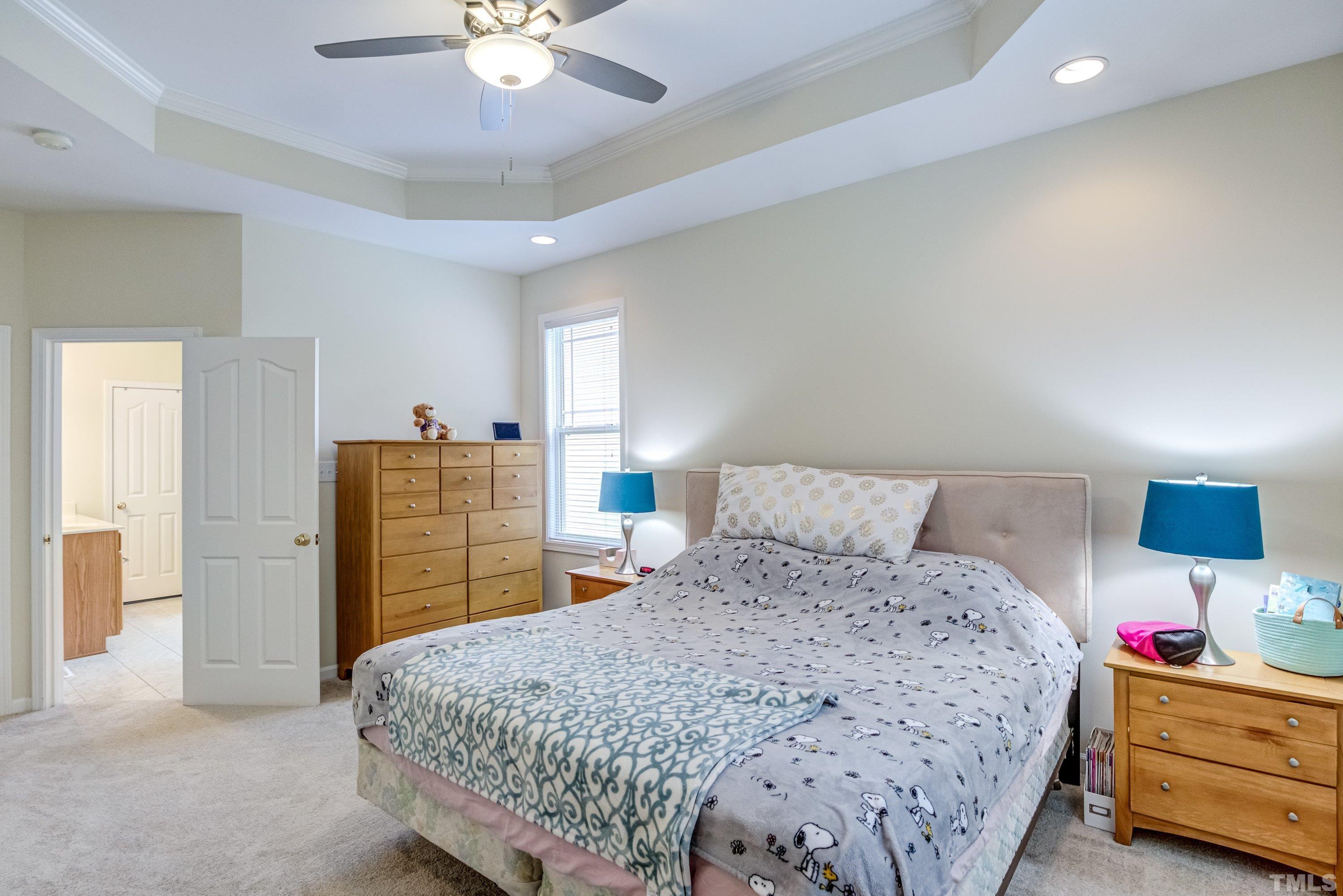 8613 Benzinger Drive Raleigh, NC 27613 - Photo 23 of 48 a bedroom with a bed and a chandelier