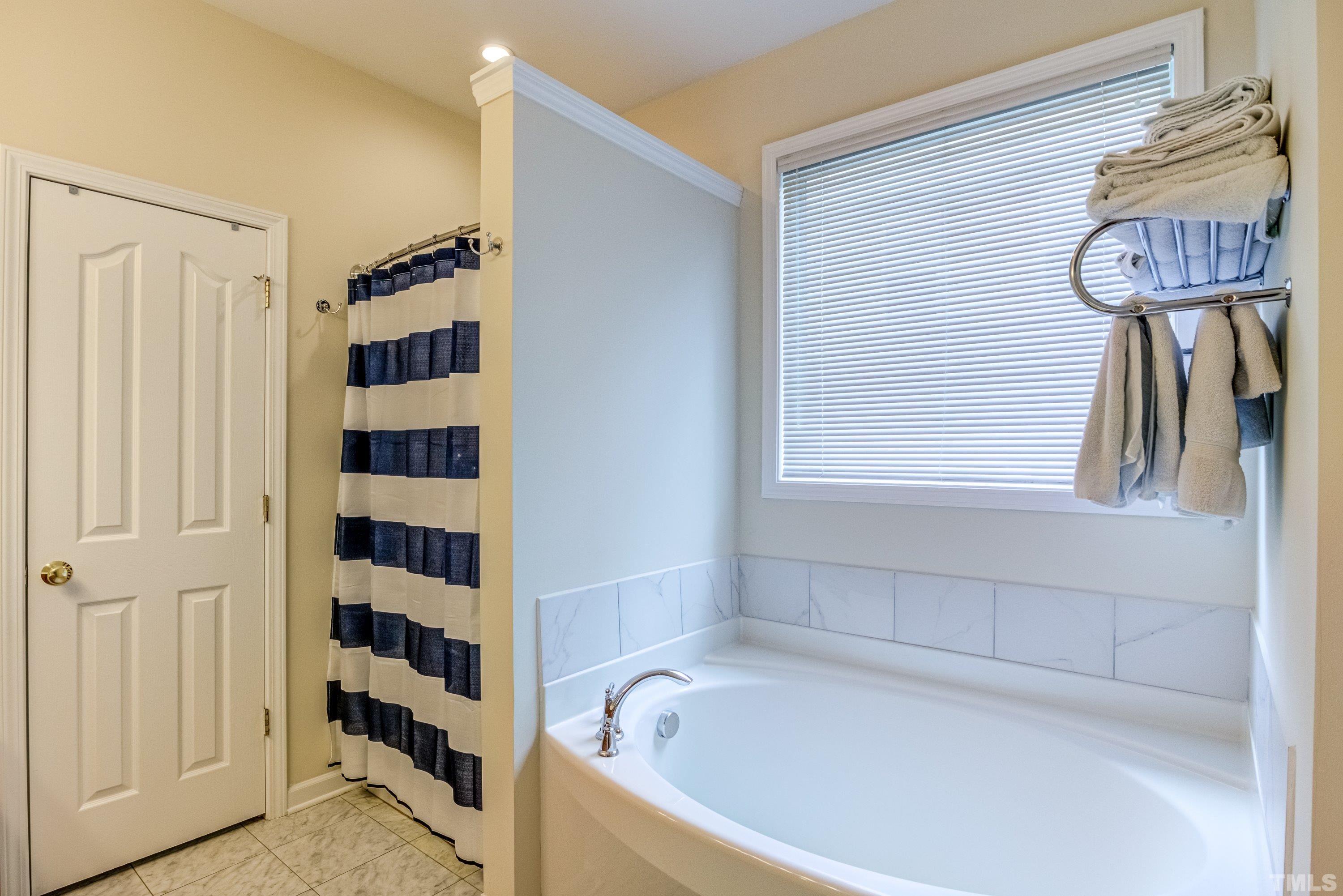 8613 Benzinger Drive Raleigh, NC 27613 - Photo 25 of 48 a bathroom with a bathtub and a shower