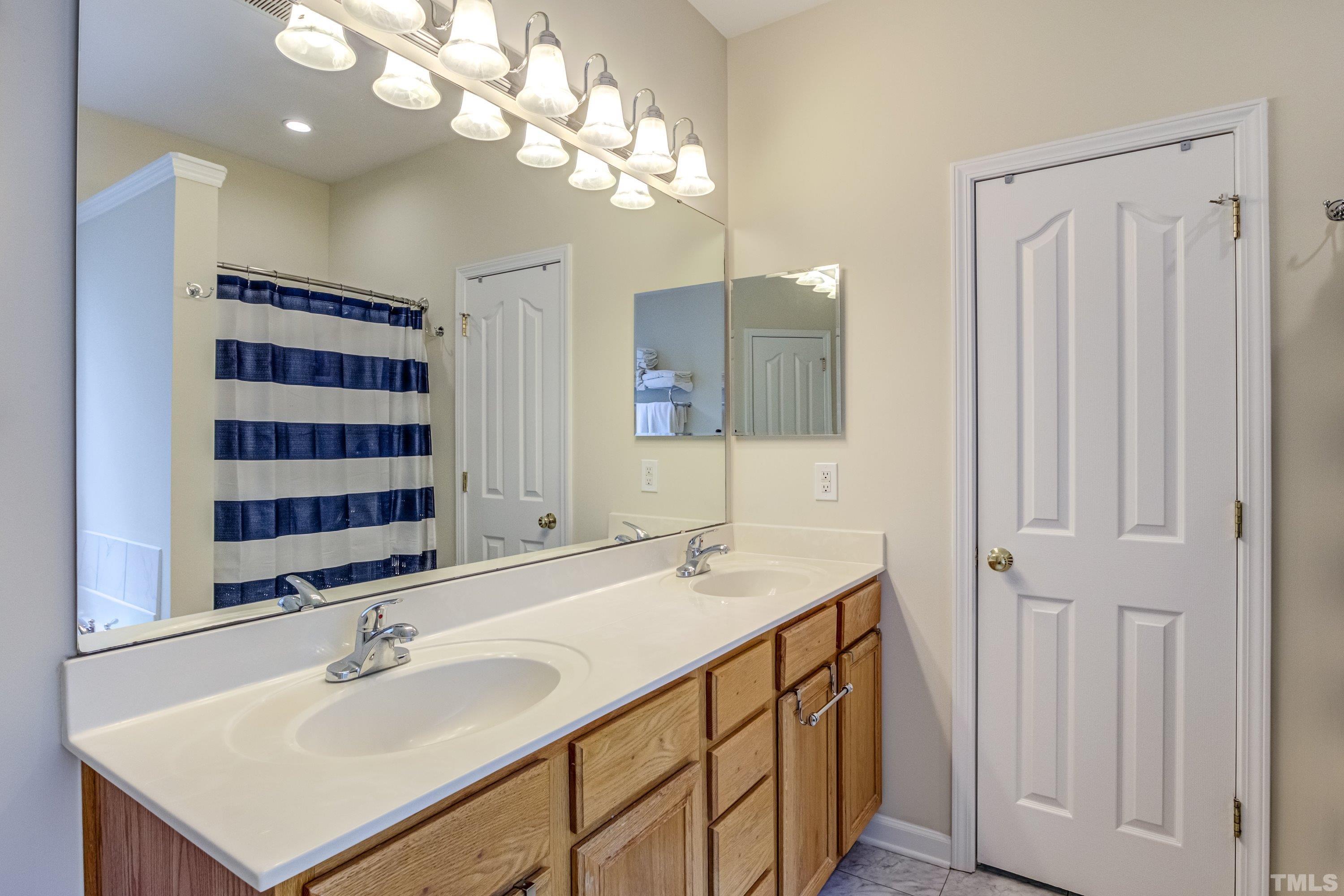 8613 Benzinger Drive Raleigh, NC 27613 - Photo 26 of 48 a bathroom with a sink double vanity and a mirror