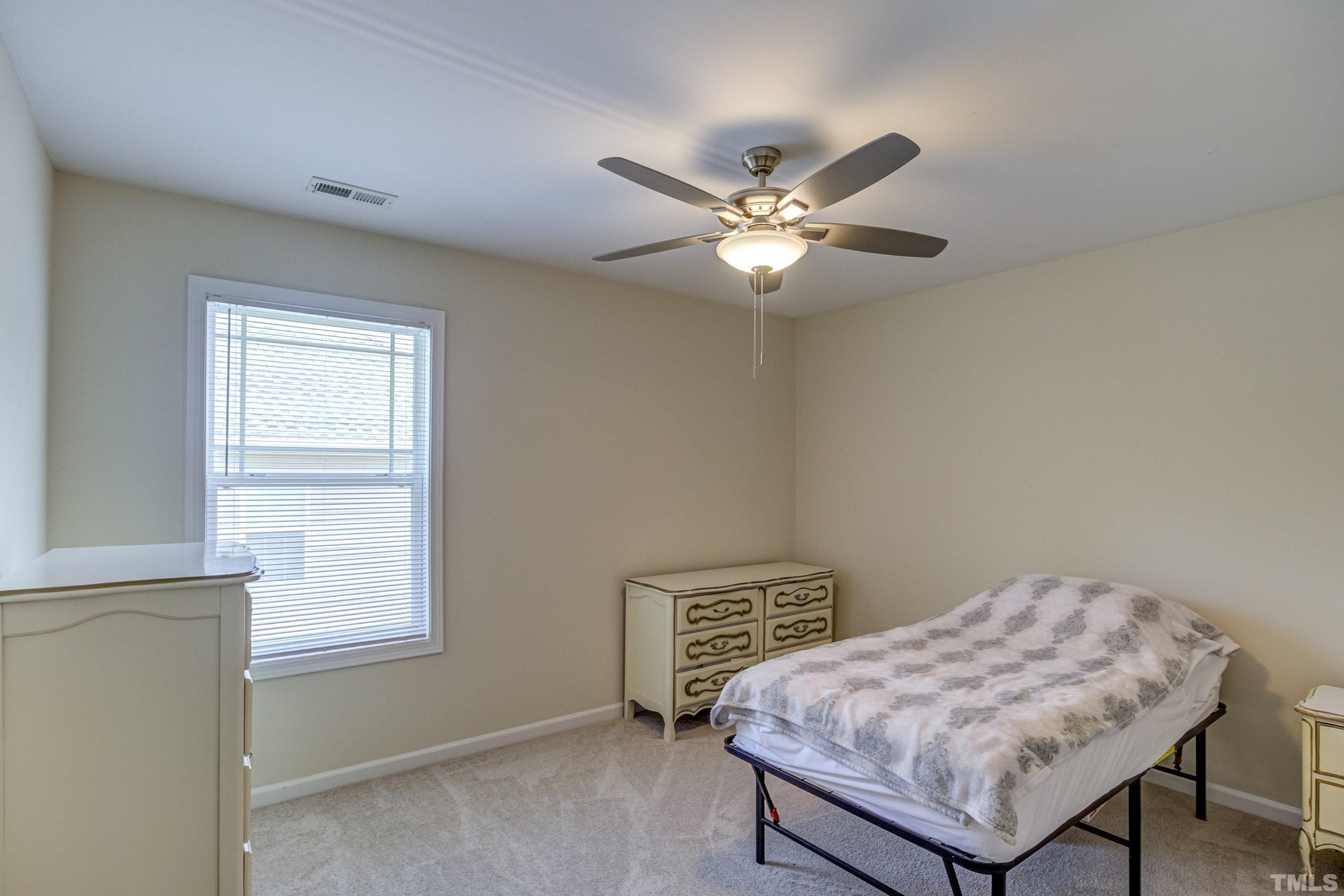 8613 Benzinger Drive Raleigh, NC 27613 - Photo 32 of 48 a bedroom with a bed window and a chair