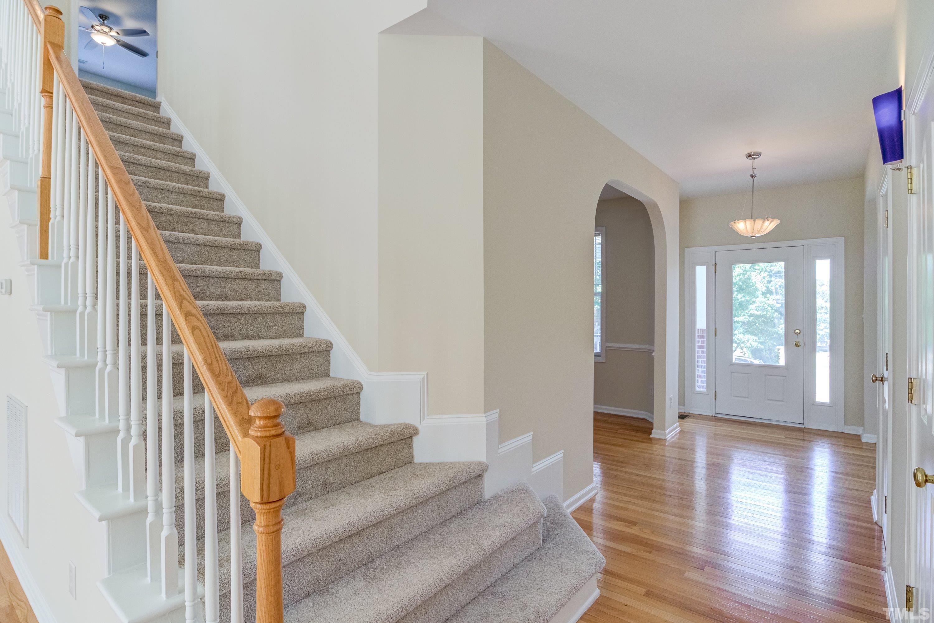 8613 Benzinger Drive Raleigh, NC 27613 - Photo 5 of 48 a view of an entryway with wooden floor and stairs