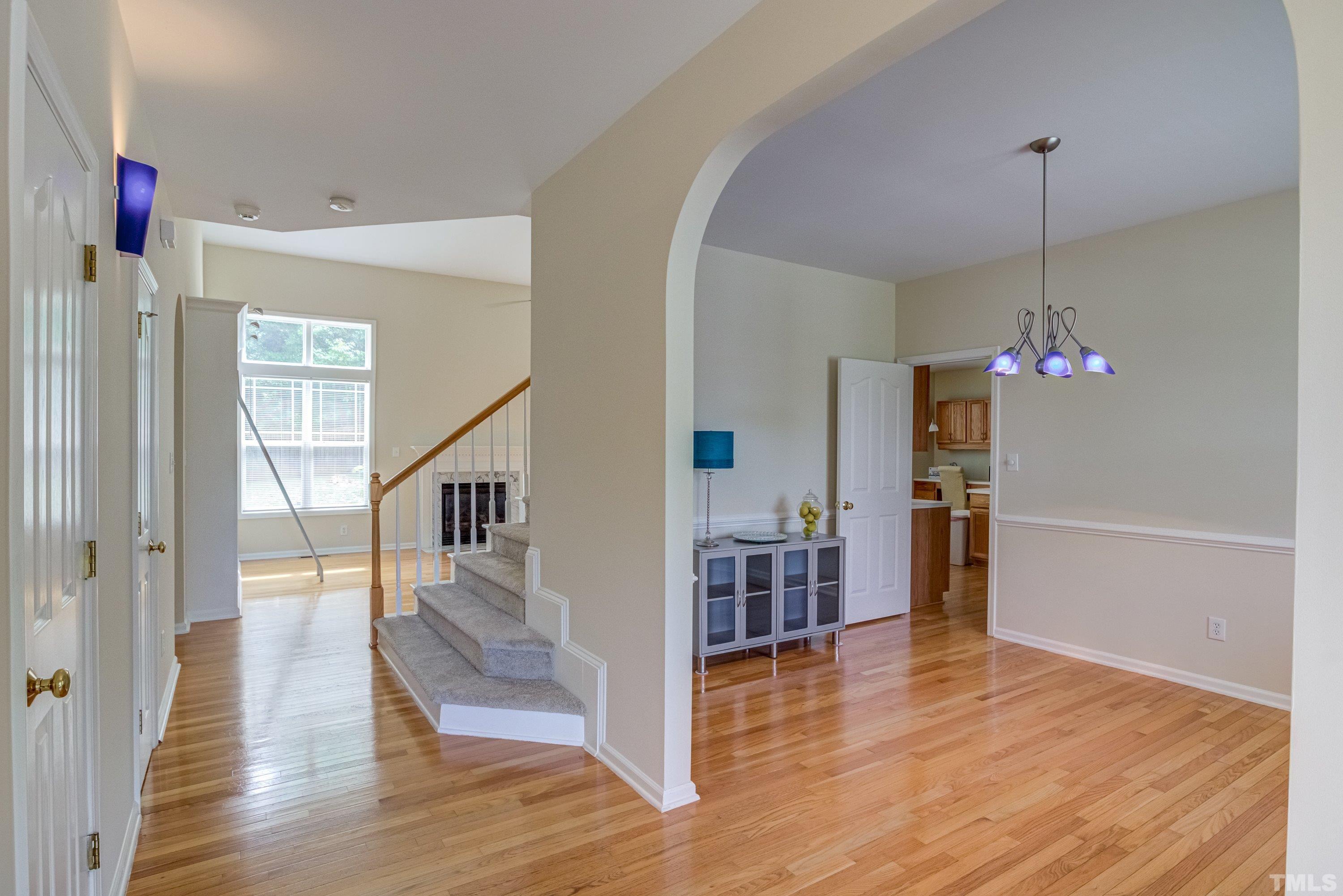 8613 Benzinger Drive Raleigh, NC 27613 - Photo 6 of 48 a view of a livingroom with wooden floor and stairs