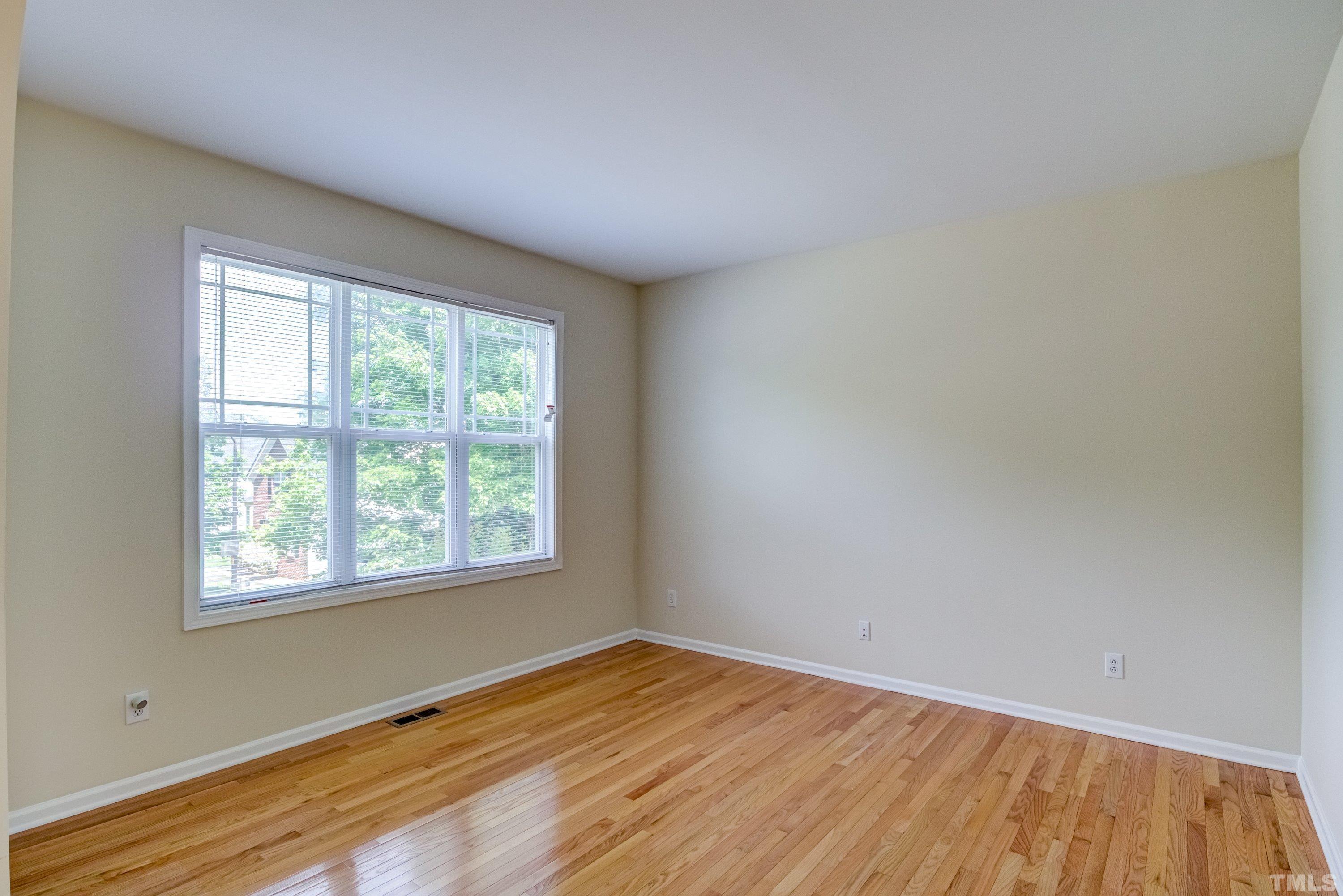 8613 Benzinger Drive Raleigh, NC 27613 - Photo 10 of 48 an empty room with wooden floor and windows