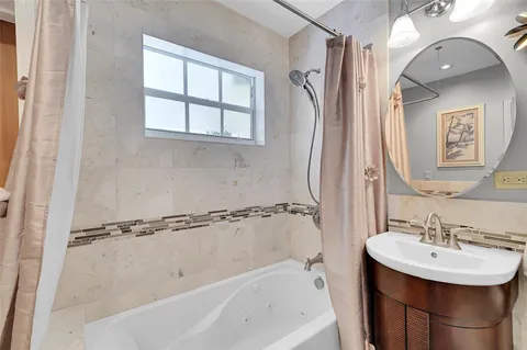 a bathroom with a sink a mirror and a bathtub
