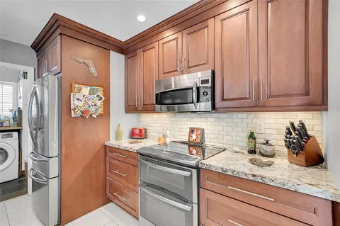 a kitchen with stainless steel appliances granite countertop a refrigerator sink and microwave