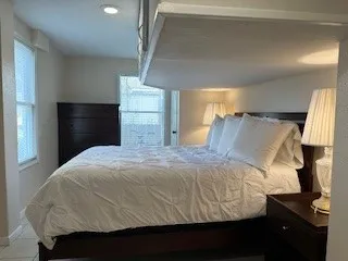 a large bed sitting in a bedroom next to a lamp