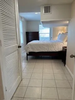 a large bed sitting in a bedroom next to a window