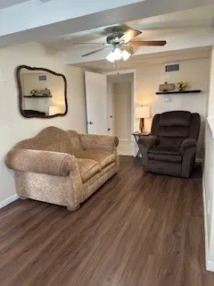 a living room with a bed furniture and wooden floor