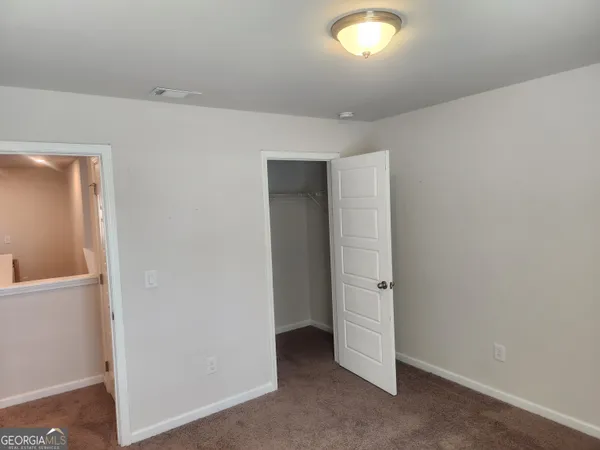 an empty room with closet and wooden floor