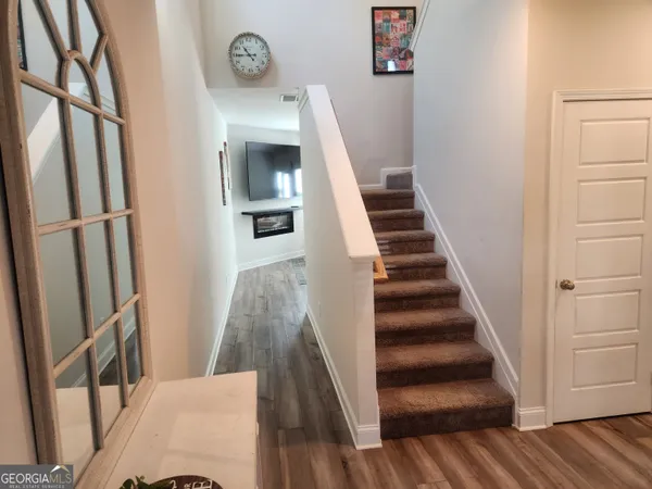 a view of entryway and hall with wooden floor