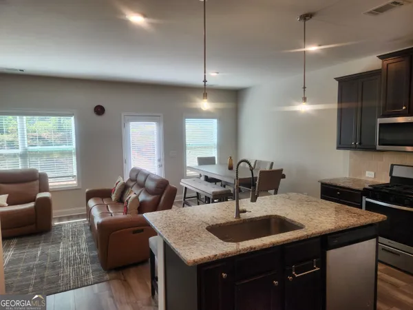 a kitchen with granite countertop a sink a counter top space and living room