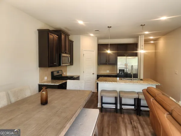 a kitchen with a table chairs refrigerator and microwave