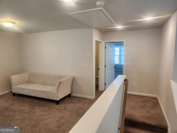 a living room with furniture and a walk in closet