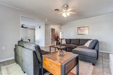 a living room with furniture a chandelier and a flat screen tv