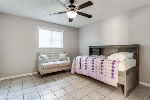 a bedroom with a bed and a chandelier fan