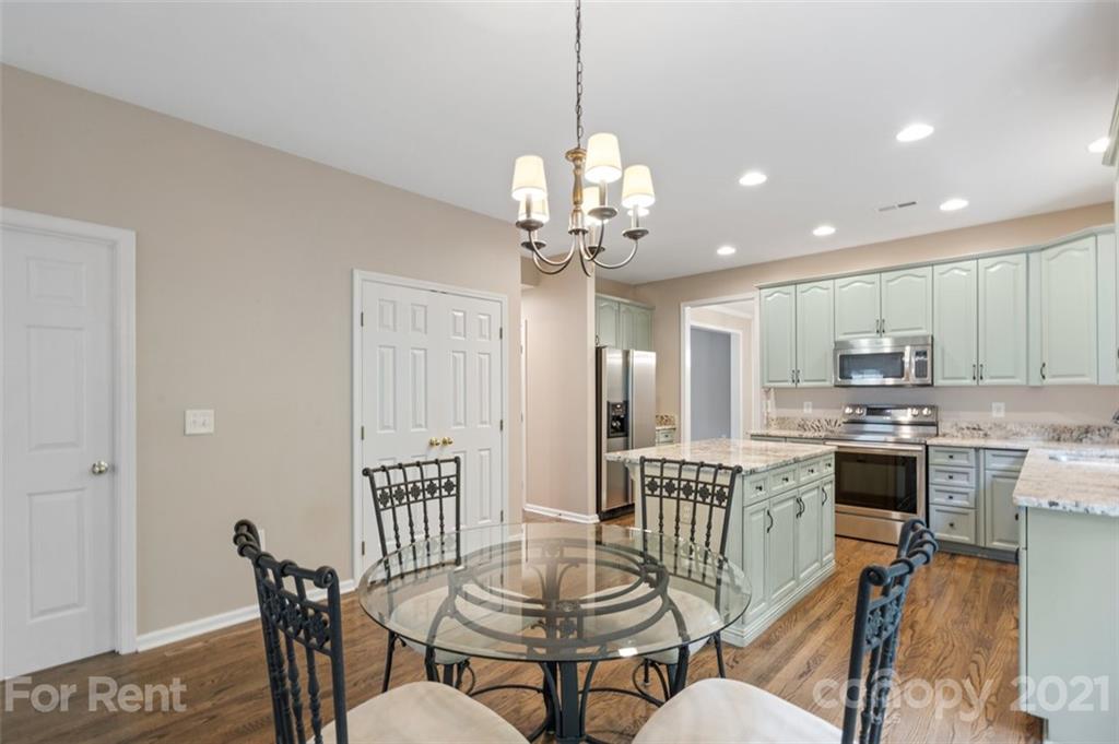 3028 Strawberry Road Matthews, NC 28104 - Photo 13 of 40 a view of a dining room with furniture a chandelier and kitchen view
