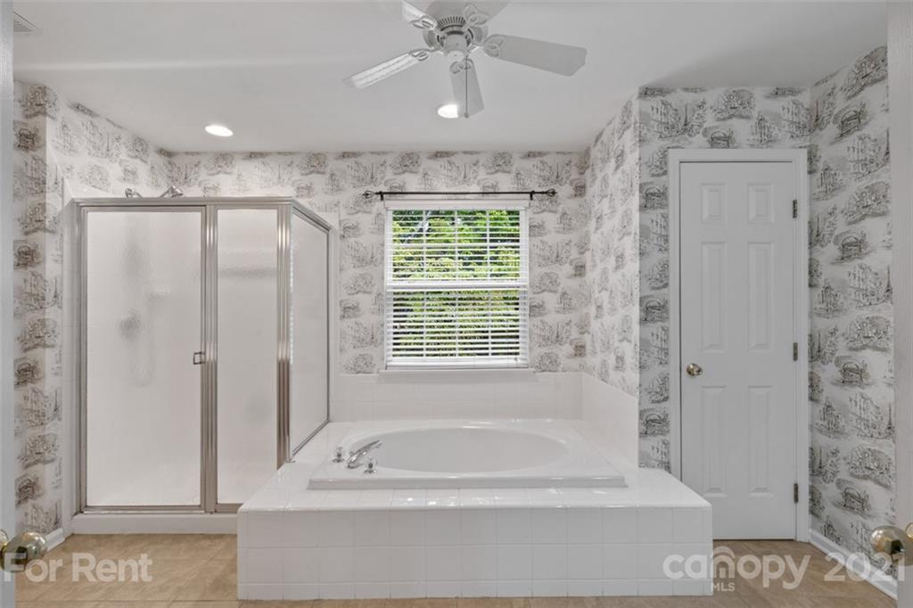 3028 Strawberry Road Matthews, NC 28104 - Photo 31 of 40 a bathroom with a bathtub and a shower