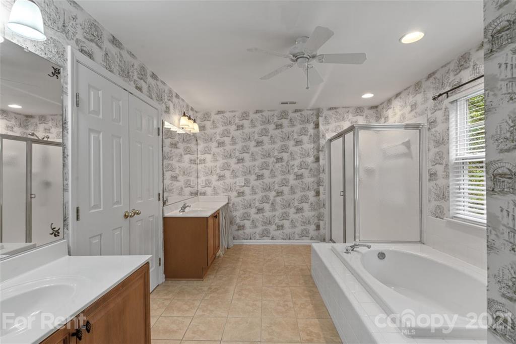 3028 Strawberry Road Matthews, NC 28104 - Photo 32 of 40 a bathroom with a bathtub shower sink vanity and toilet