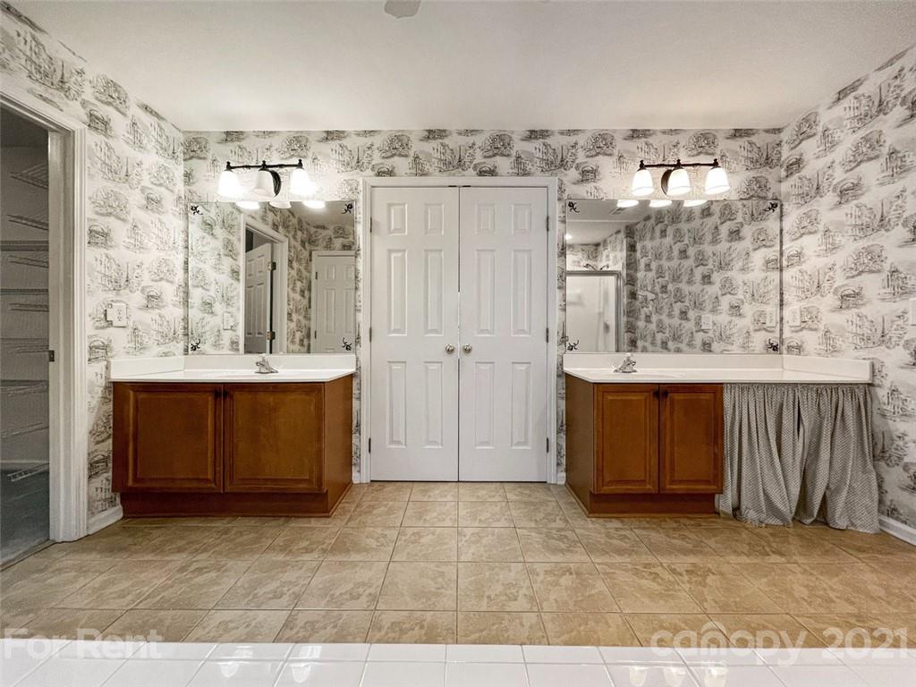 3028 Strawberry Road Matthews, NC 28104 - Photo 33 of 40 a bathroom with a sink a mirror and a shower