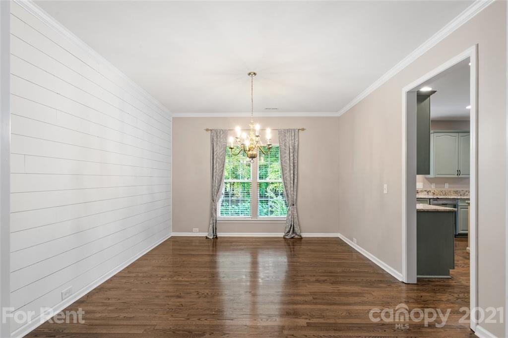 3028 Strawberry Road Matthews, NC 28104 - Photo 5 of 40 a view of an empty room with wooden floor and a window