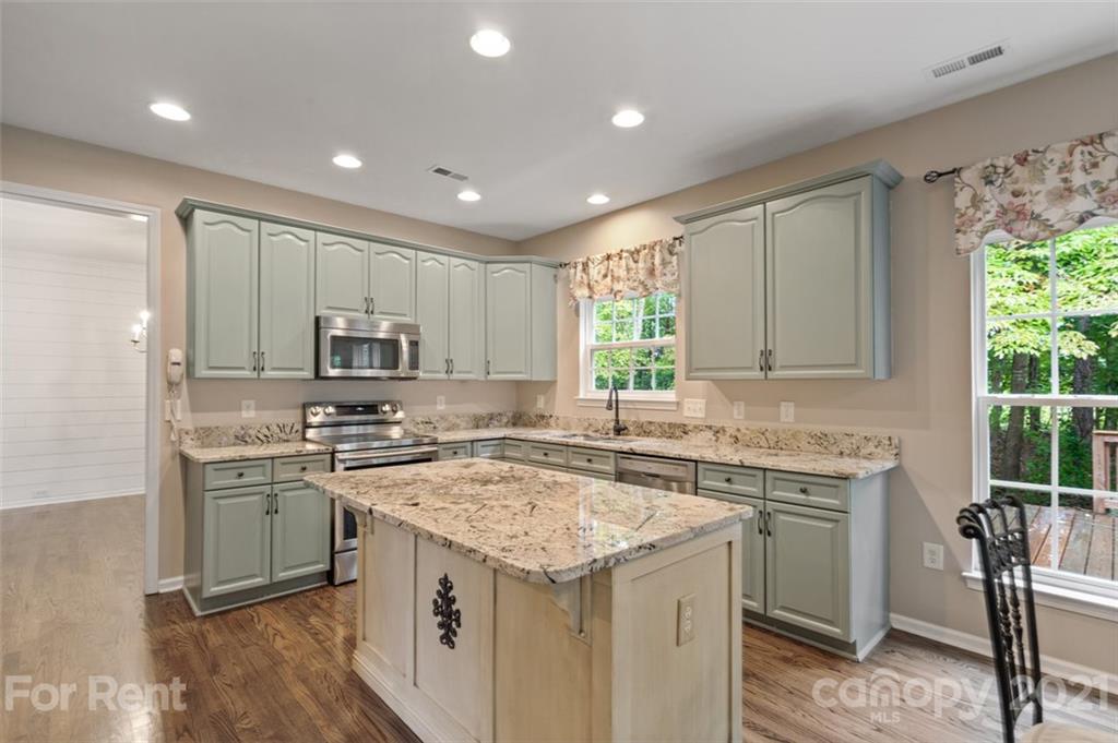 3028 Strawberry Road Matthews, NC 28104 - Photo 7 of 40 a kitchen with stainless steel appliances granite countertop a sink stove and refrigerator