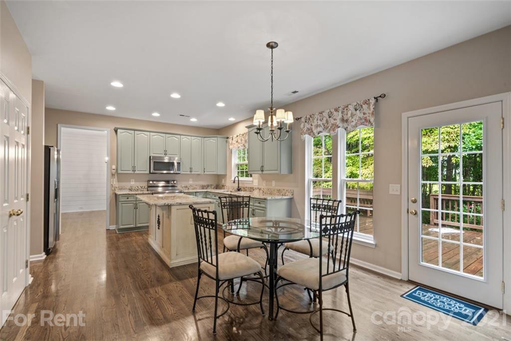 3028 Strawberry Road Matthews, NC 28104 - Photo 10 of 40 a view of a dining room and livingroom with furniture wooden floor a chandelier