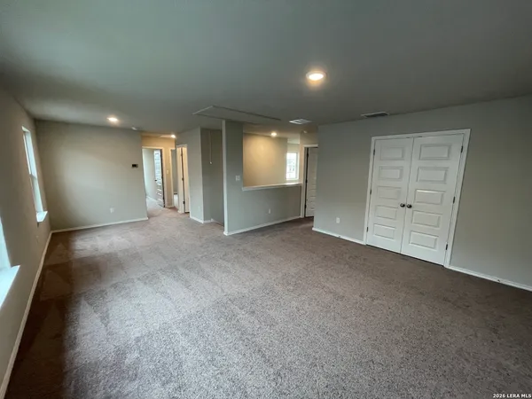 an empty room with wooden floor and entrance