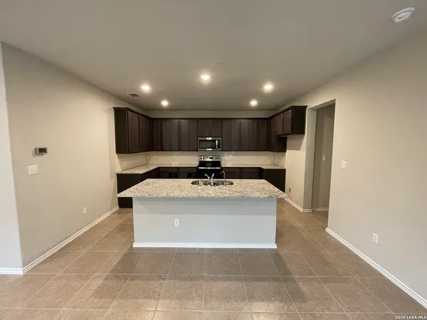a view of a kitchen with a sink and a refrigerator