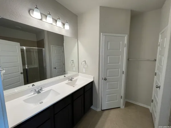 a bathroom with a double vanity sink a mirror and a shower