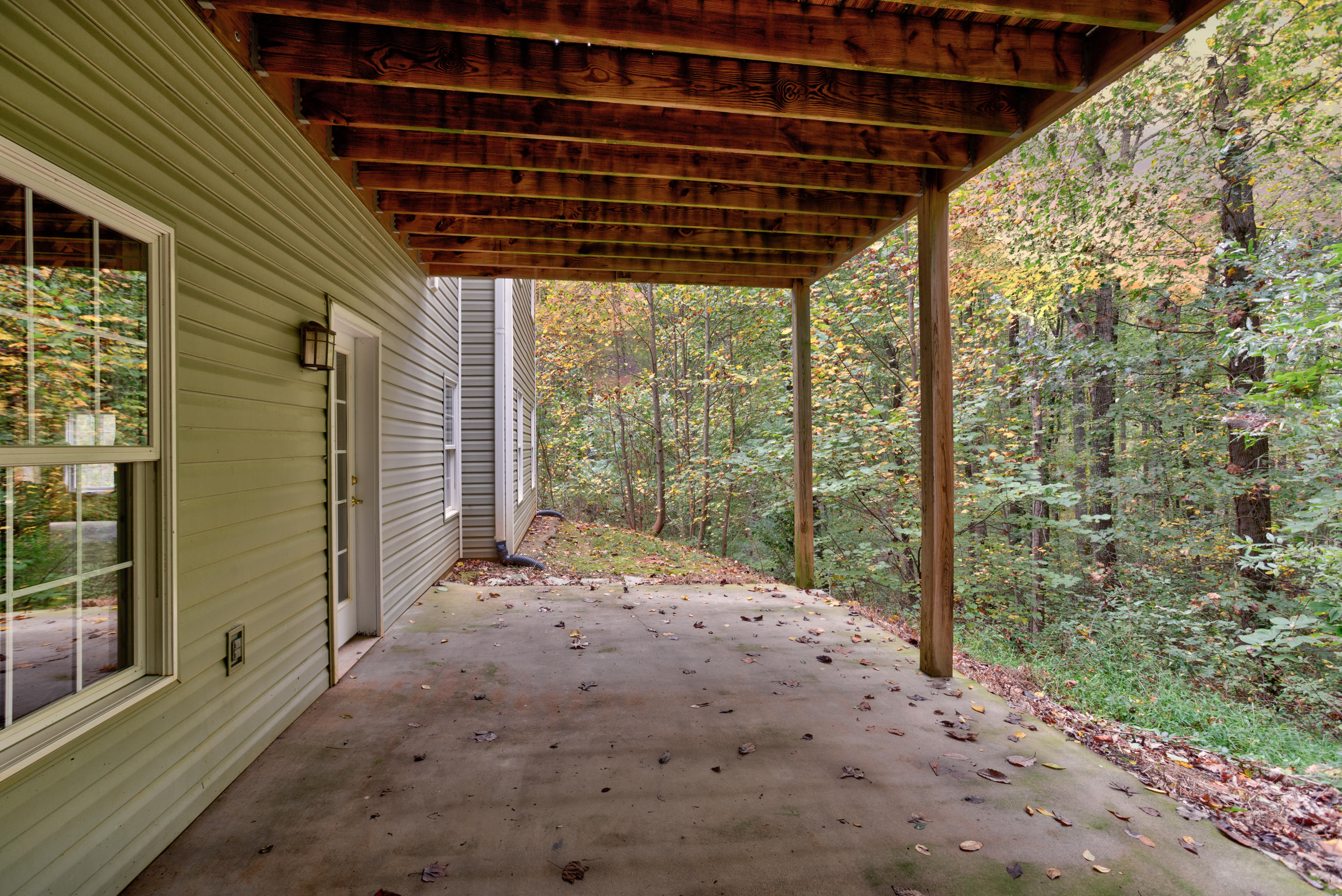 2480 Iron Ridge Road Rocky Mount, VA 24151 - Photo 8 of 38 a backyard of a house with large trees and a wooden bench