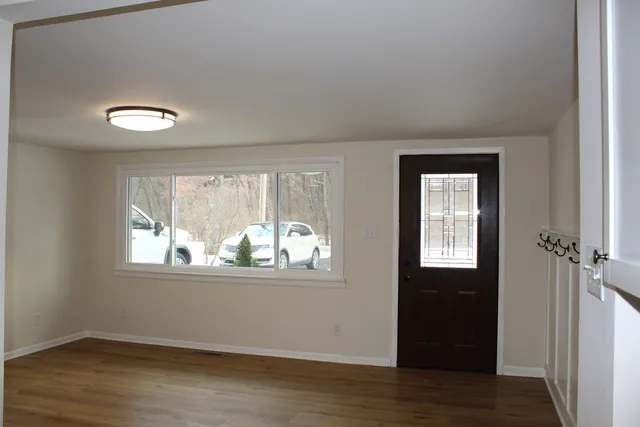 an empty room with wooden floor and windows