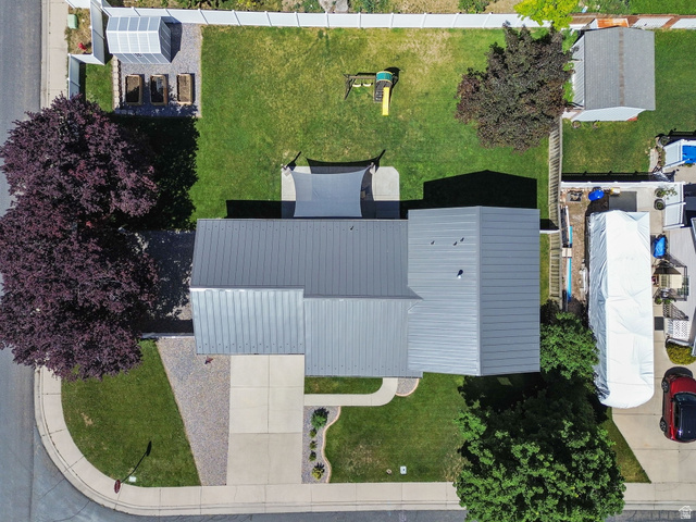 415 360 East Salem, UT 84653 - Photo 18 of 20 Property featuring a gray metal roof, expansive green lawn, dedicated garden area with a greenhouse, concrete patio, and mature trees