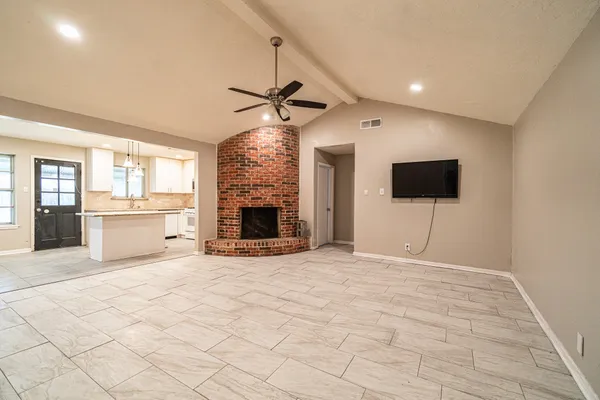 a view of empty room with fireplace and wooden floor