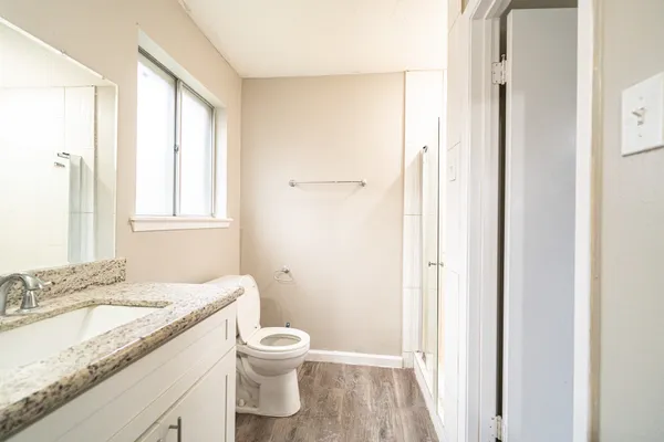a bathroom with a granite countertop sink toilet and shower